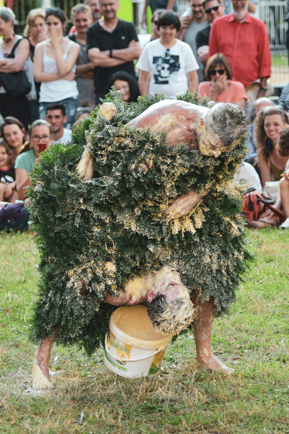 a man is holding a bucket full of plants