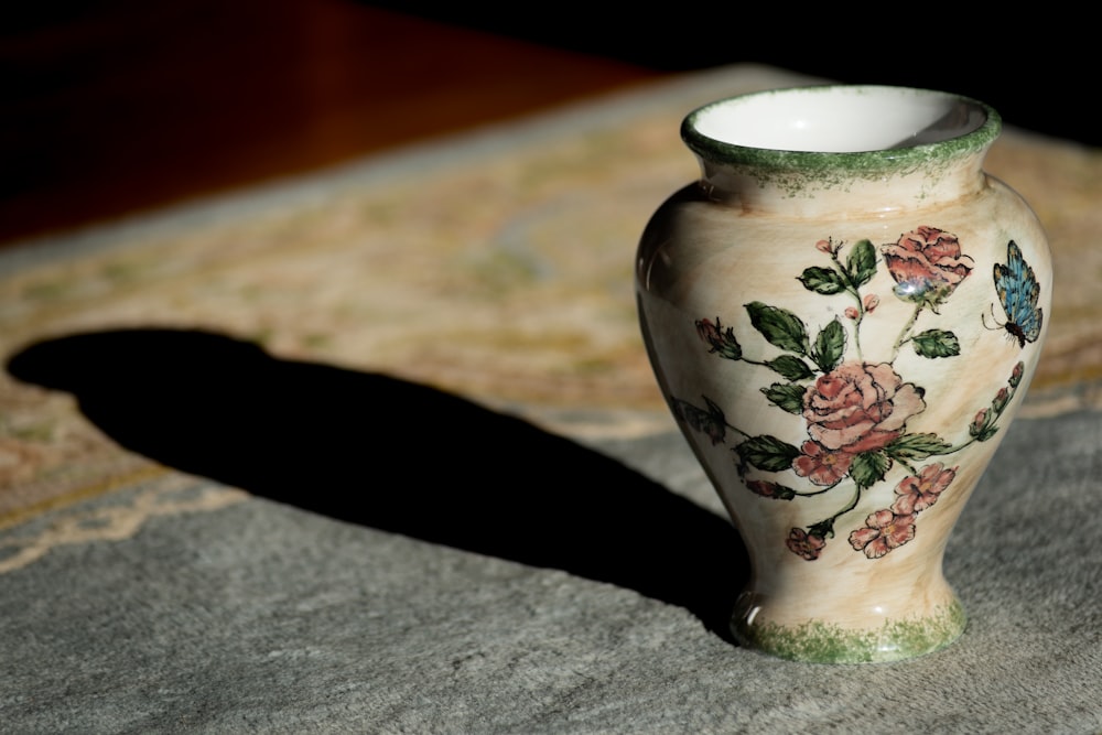 a vase sitting on top of a rug on a floor