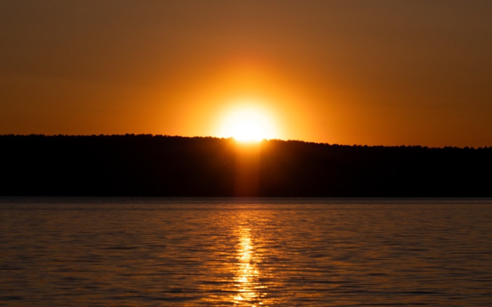 the sun is setting over a body of water