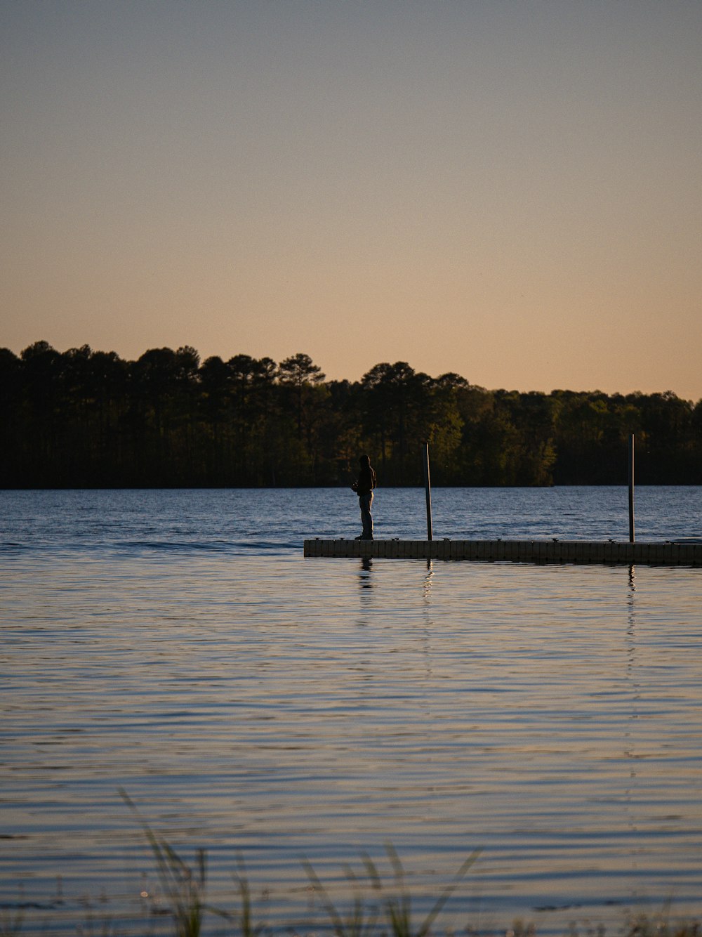 a person standing on a dock in the water