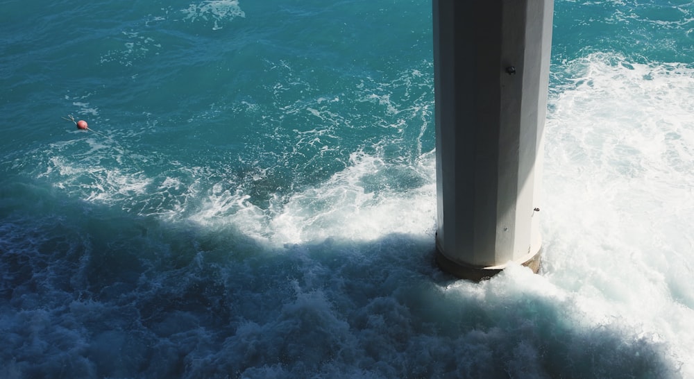 a pole sticking out of the ocean water