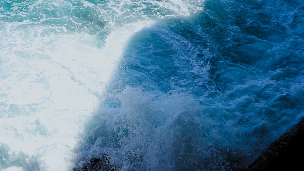 a man riding a surfboard on top of a wave