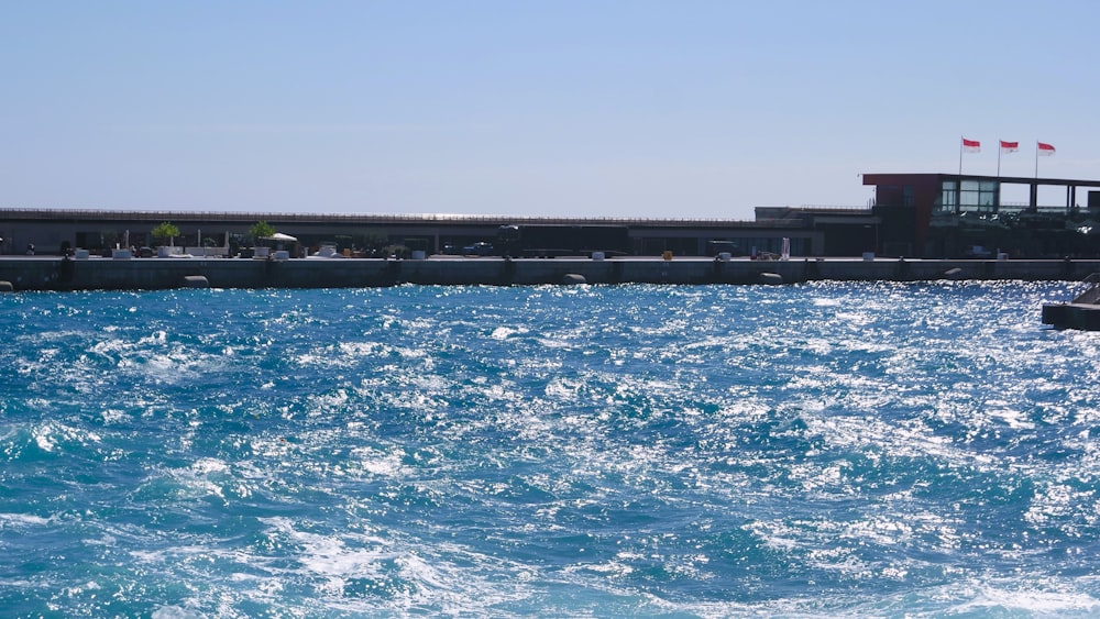 a large body of water with a building in the background