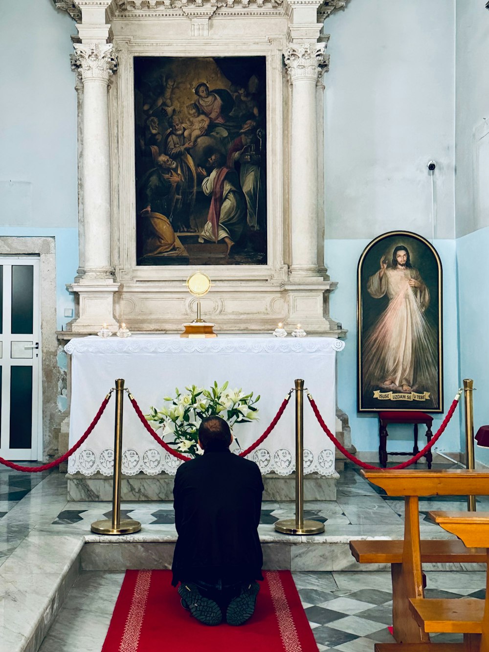 a man kneeling down in front of a painting