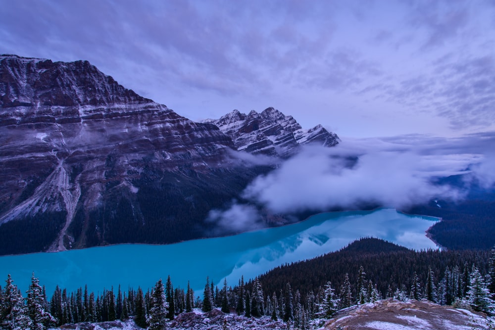 a view of a lake surrounded by snow covered mountains