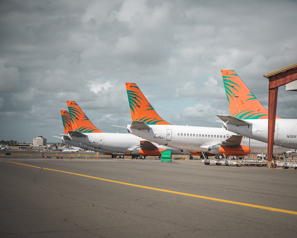 a row of airplanes sitting on top of an airport tarmac