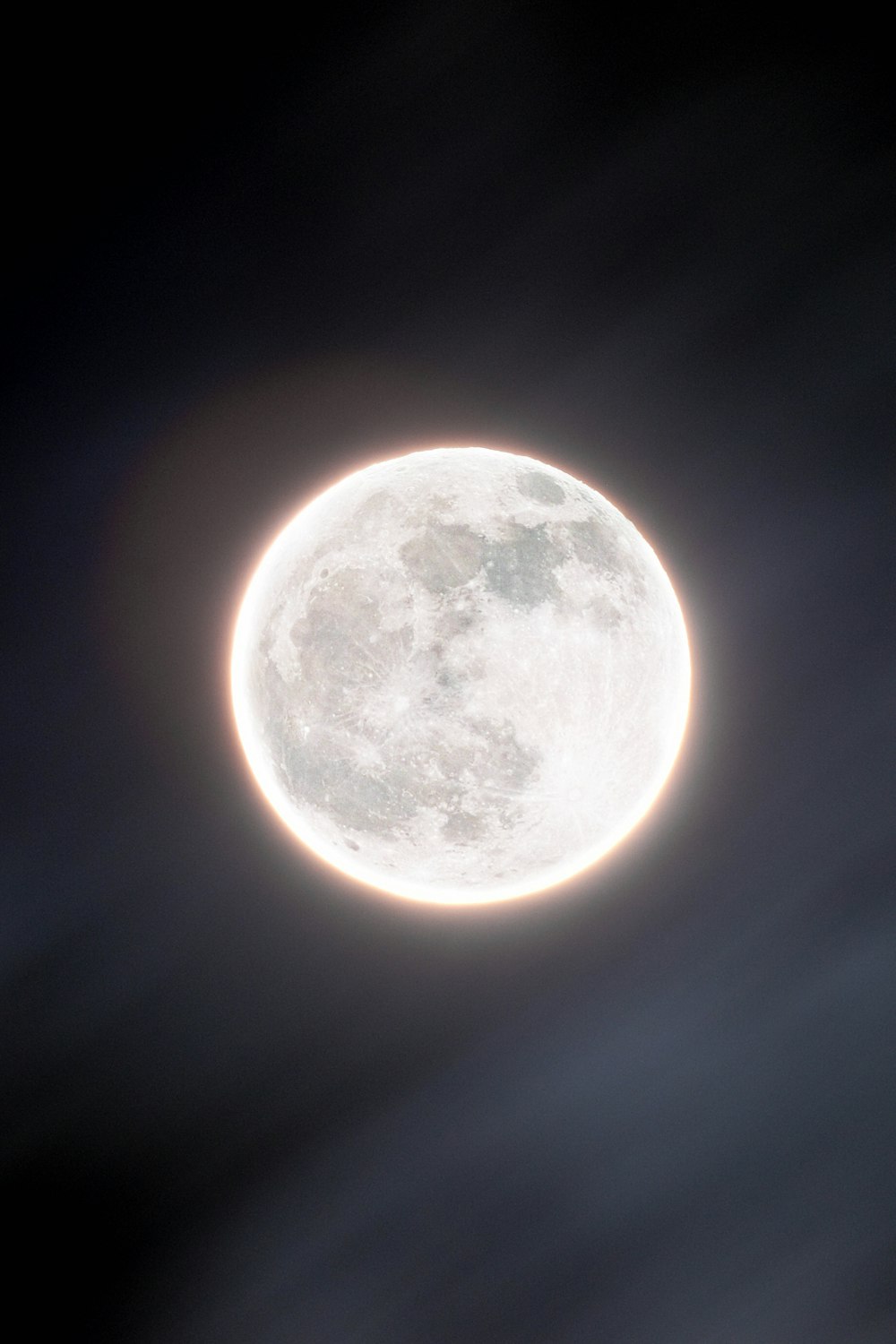 a full moon is seen in the dark sky