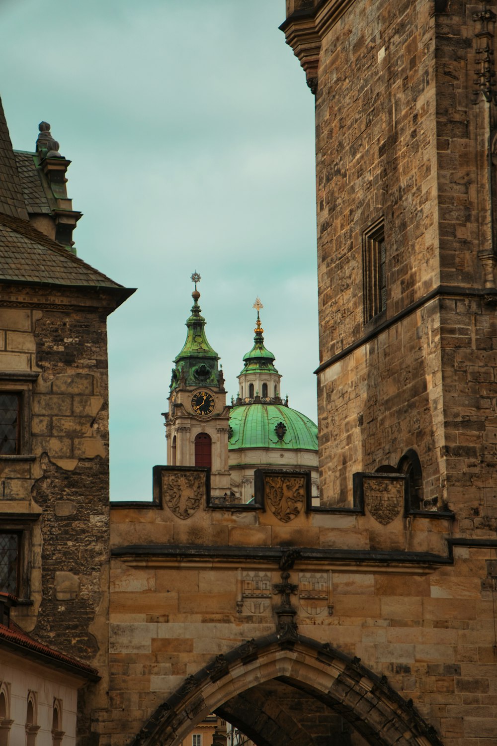 a stone building with a green roof and a green dome