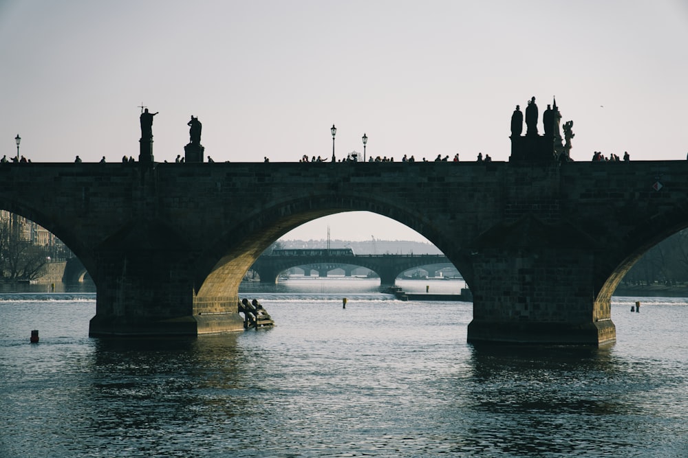 a group of people on a boat in the water under a bridge