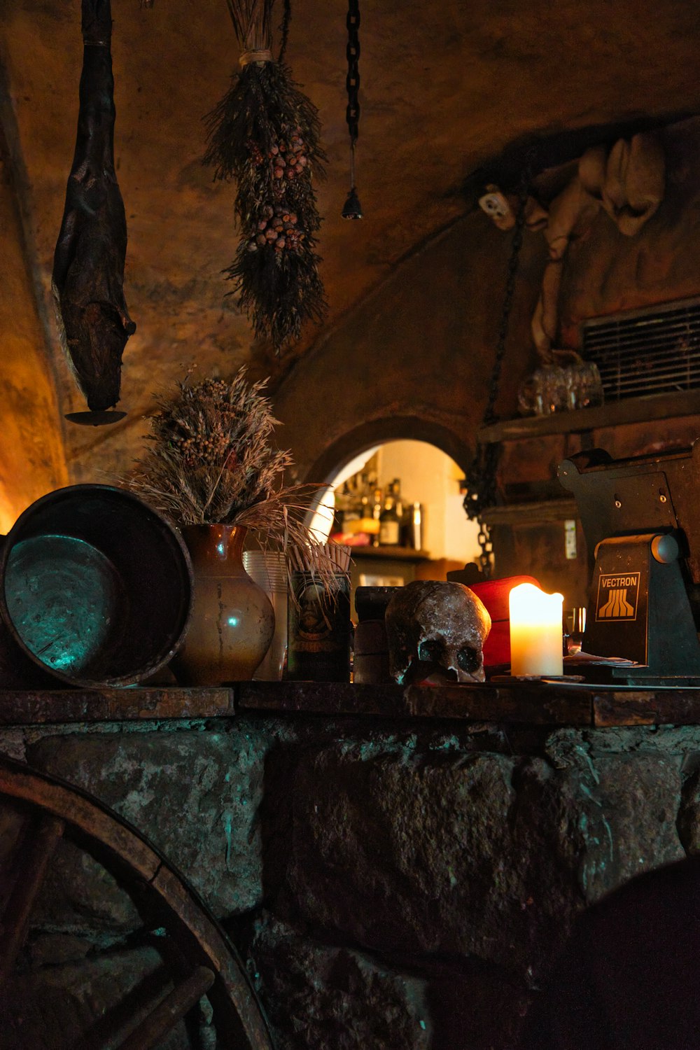 a table topped with a candle next to a stone wall