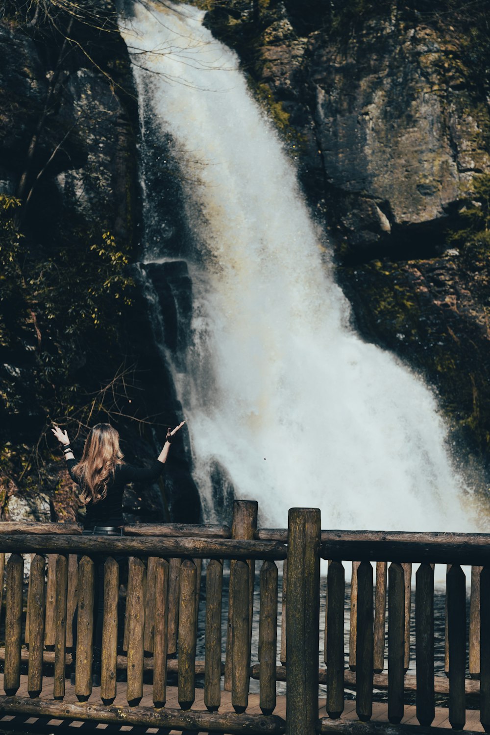 a wooden bench sitting next to a waterfall