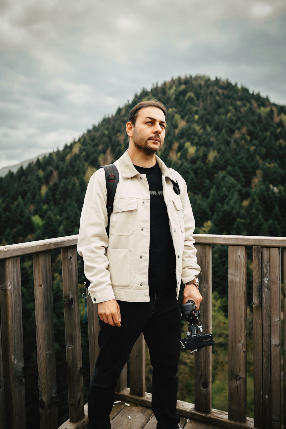 a man standing on a deck holding a camera