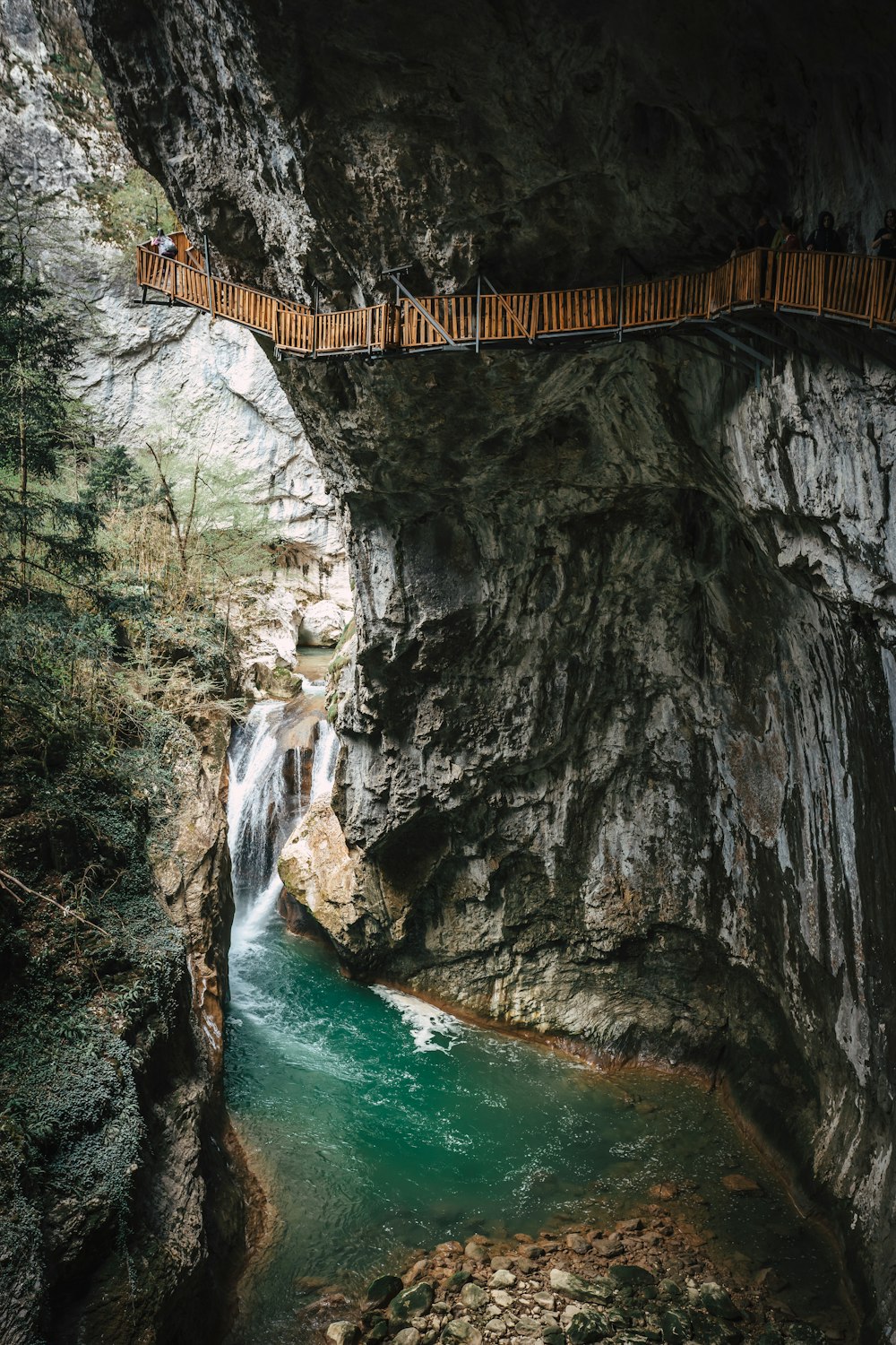 un pont au-dessus d’une rivière avec une cascade en arrière-plan