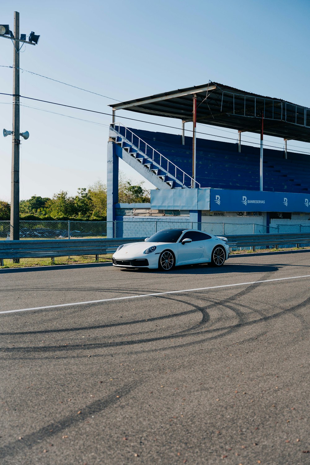 a white sports car parked in front of a stadium