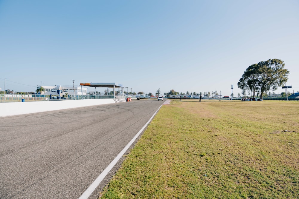 an empty road with a gas station in the background