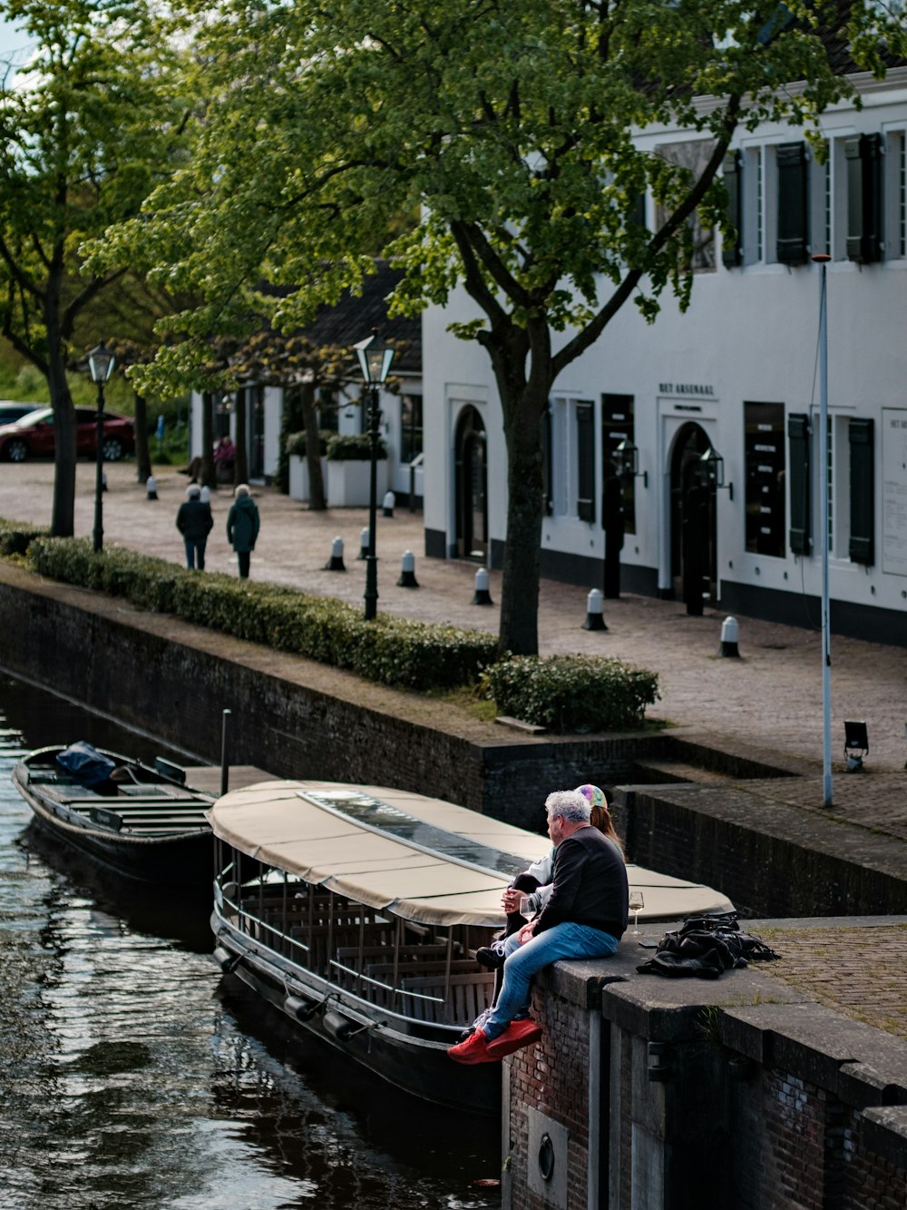 a woman sitting on a wall next to a body of water