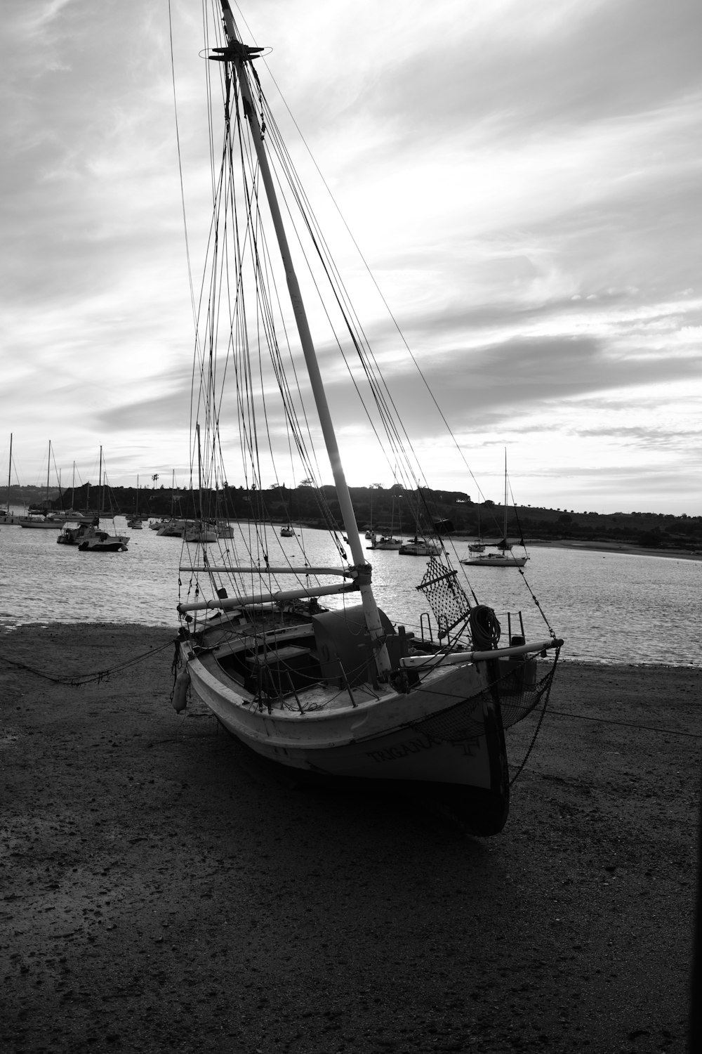 a black and white photo of a boat on the beach