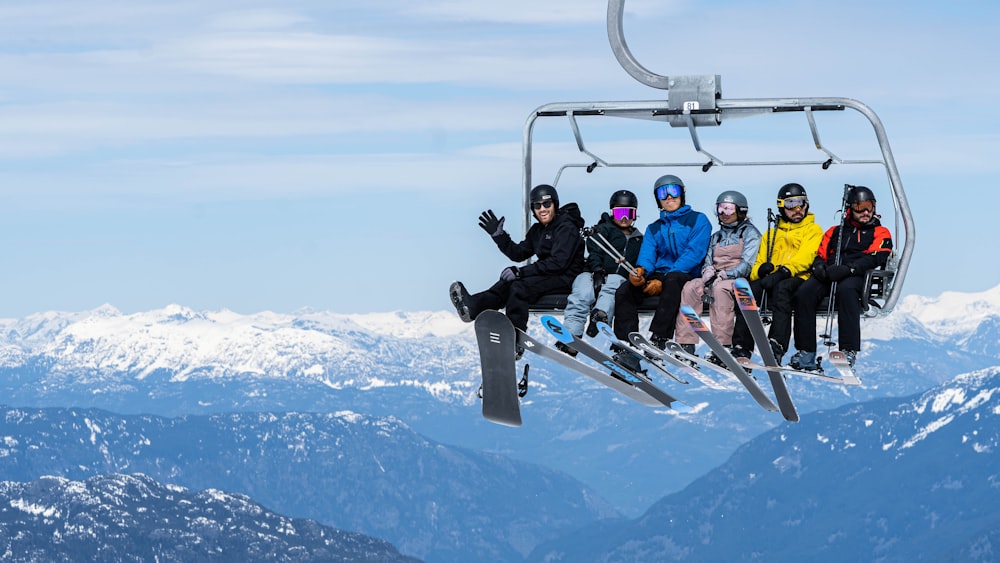 a group of people riding a ski lift up the side of a mountain