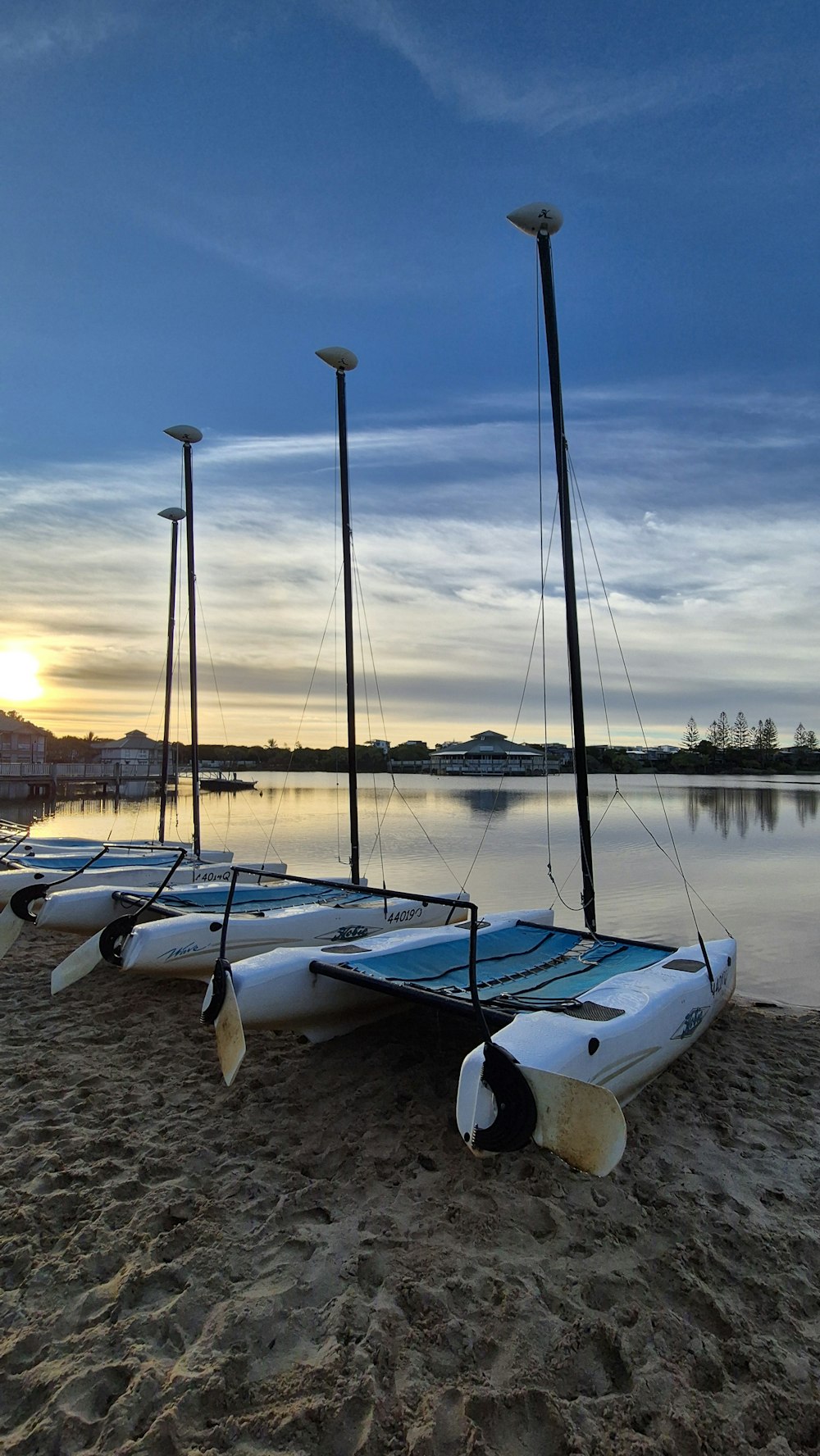 a row of boats sitting on top of a sandy beach