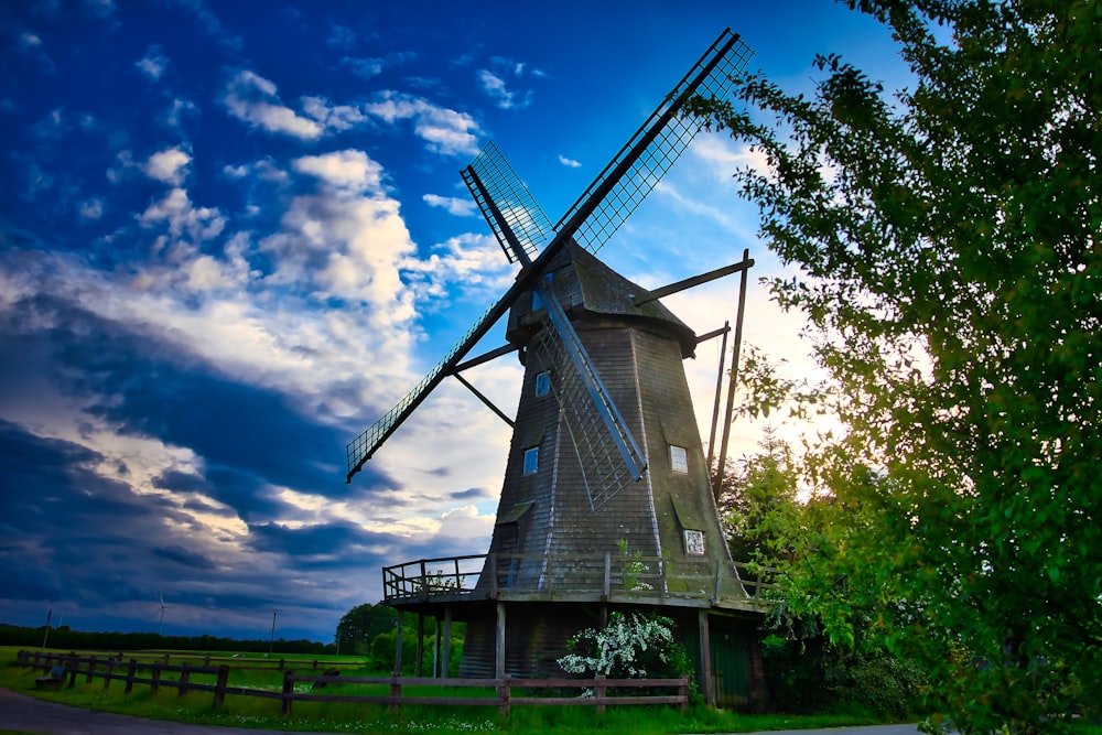 a windmill in the middle of a green field