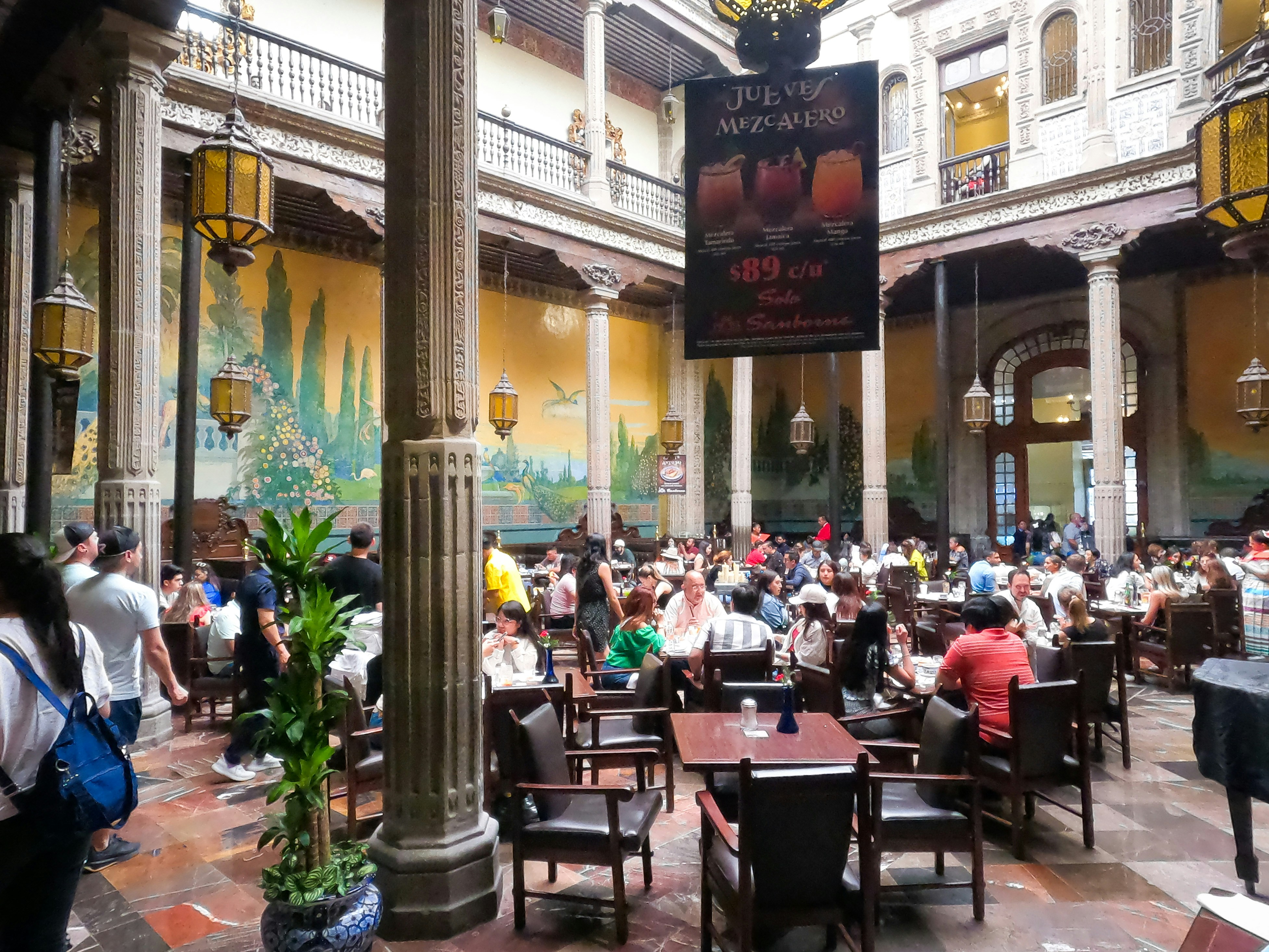 a large group of people sitting at tables in a restaurant
