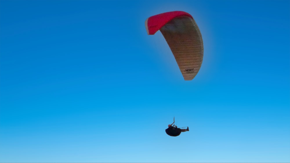 a parasailer is flying high in the blue sky