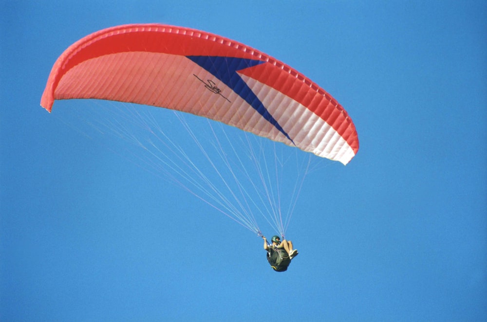 a person is parasailing in the blue sky