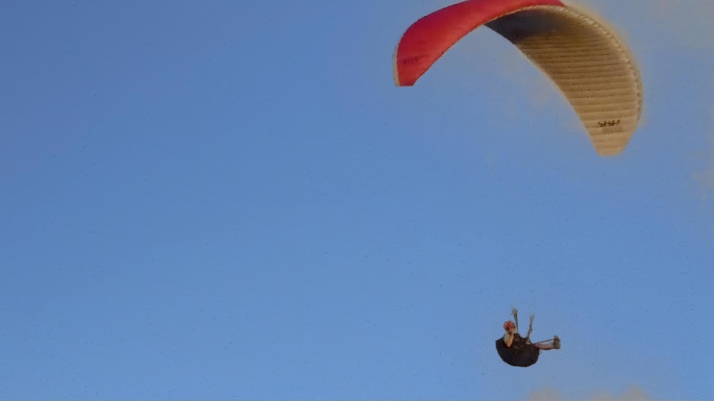 a person is parasailing in the blue sky