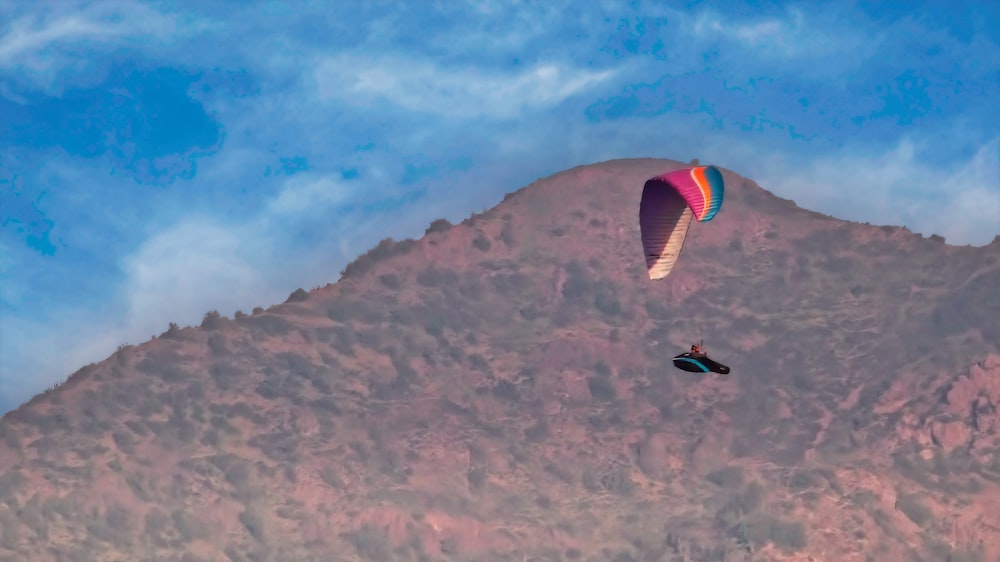 a parasailer is flying over a mountain range