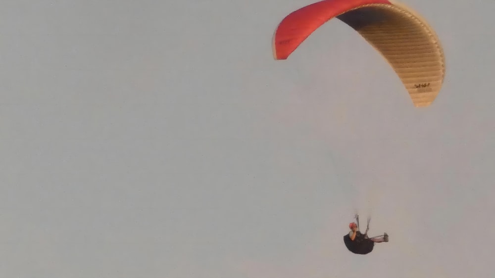 a person is parasailing in the sky on a cloudy day