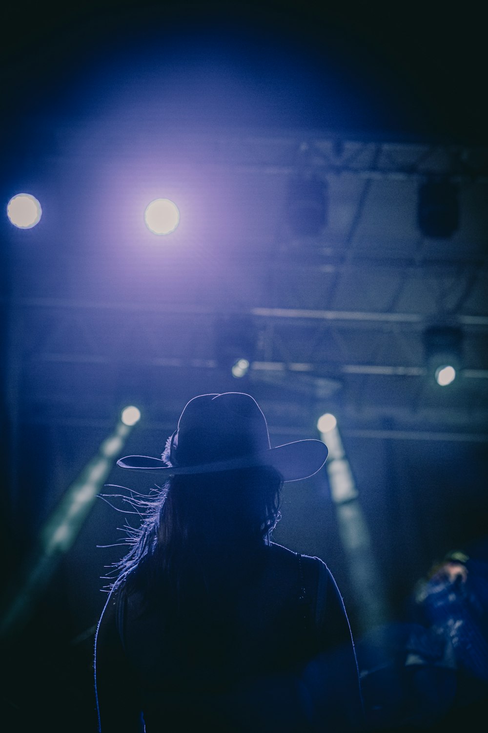 a person wearing a cowboy hat standing in front of a stage