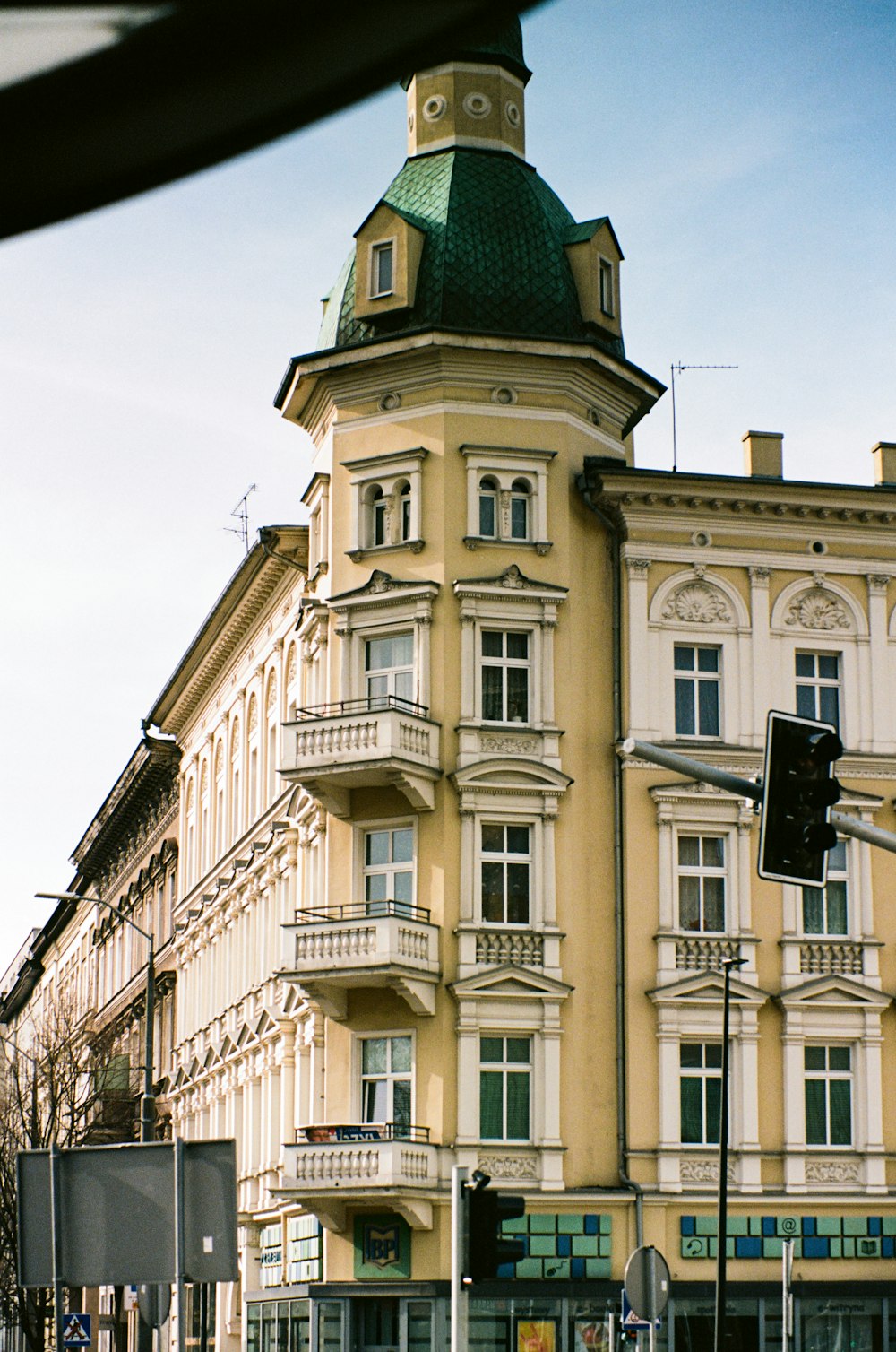 a tall building with a green roof next to a street