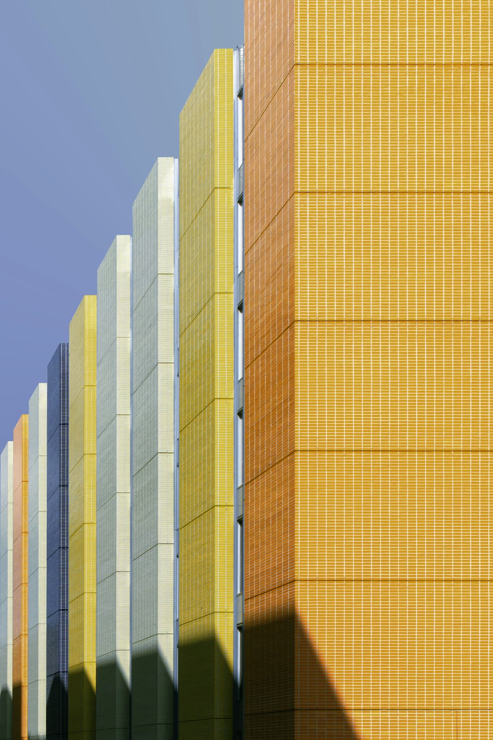 eine Reihe gelber und grauer Gebäude vor blauem Himmel