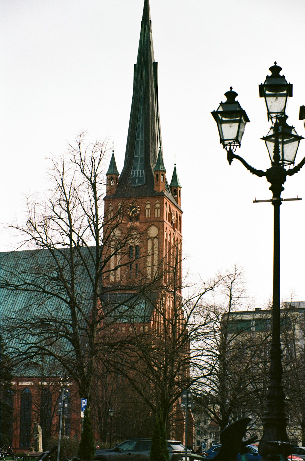 ein hohes Gebäude mit einem Kirchturm neben einer Straßenlaterne