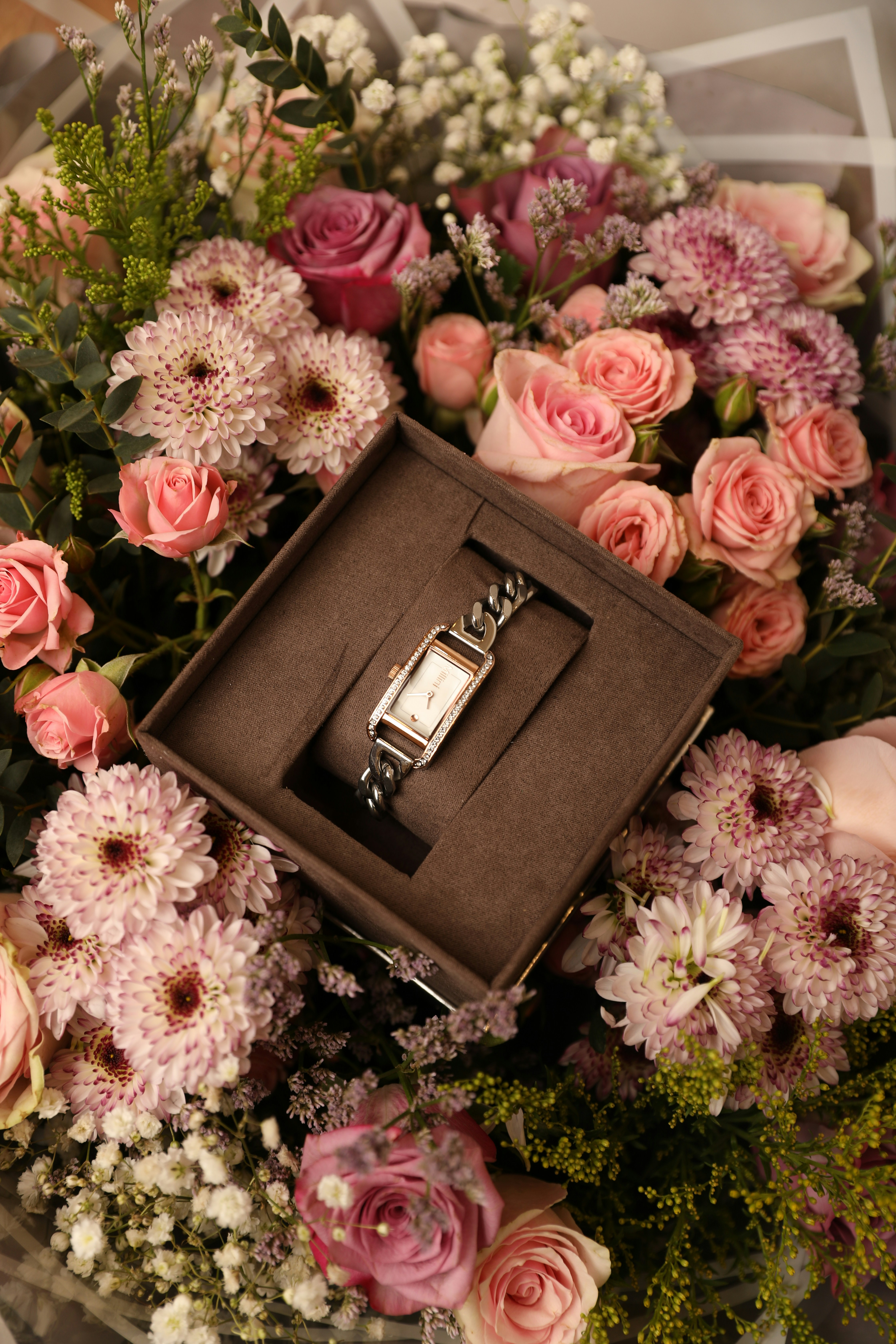 a bouquet of flowers with a watch in a box
