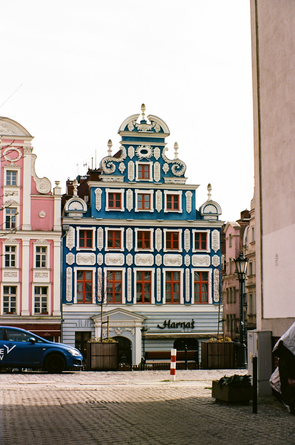 a blue car is parked in front of a building