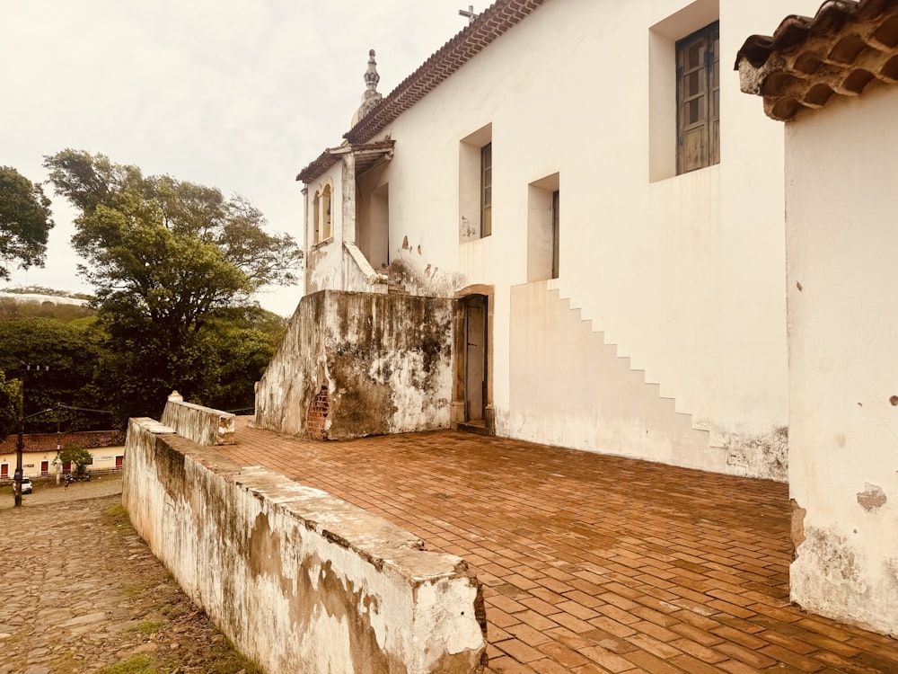 a white building with a red brick walkway next to it