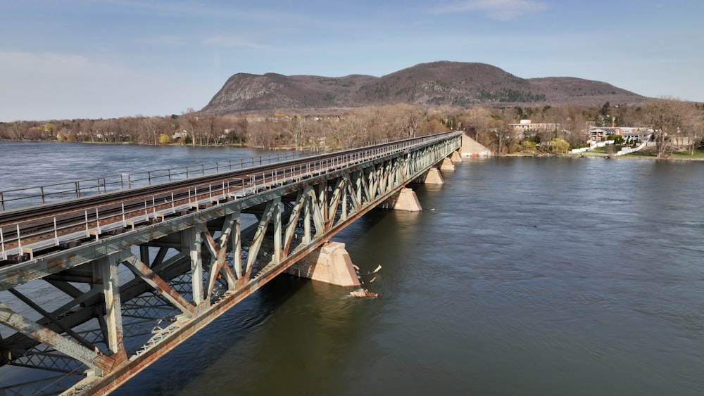 a bridge over a body of water with mountains in the background