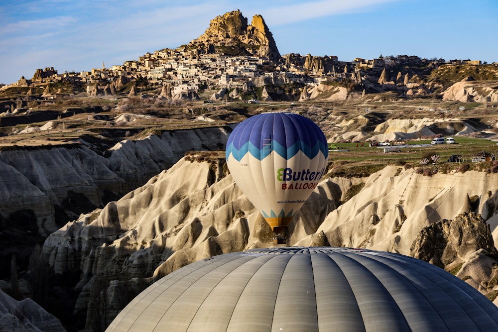 a hot air balloon flying over a rocky landscape