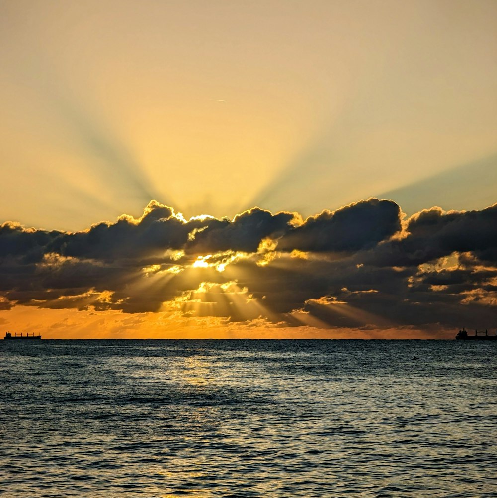 the sun is shining through the clouds over the ocean