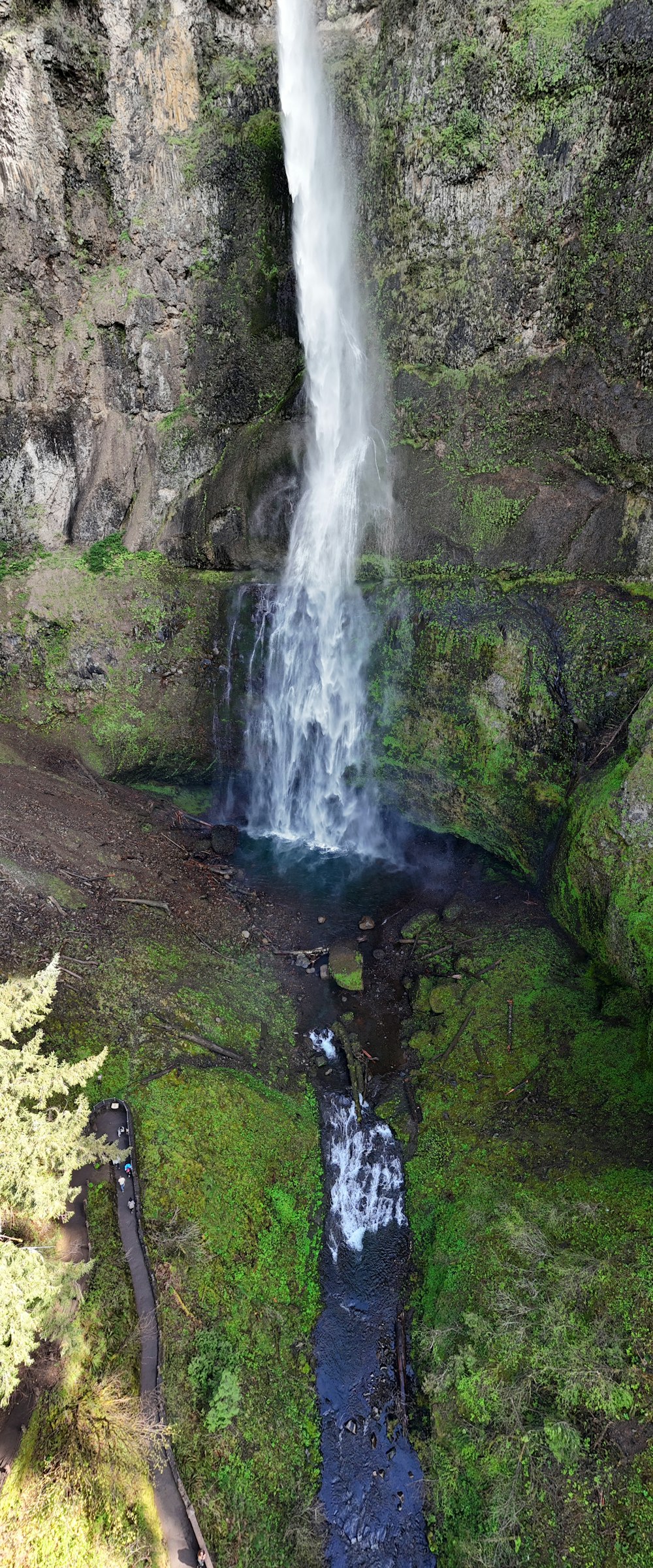 a large waterfall with a small stream in the middle of it