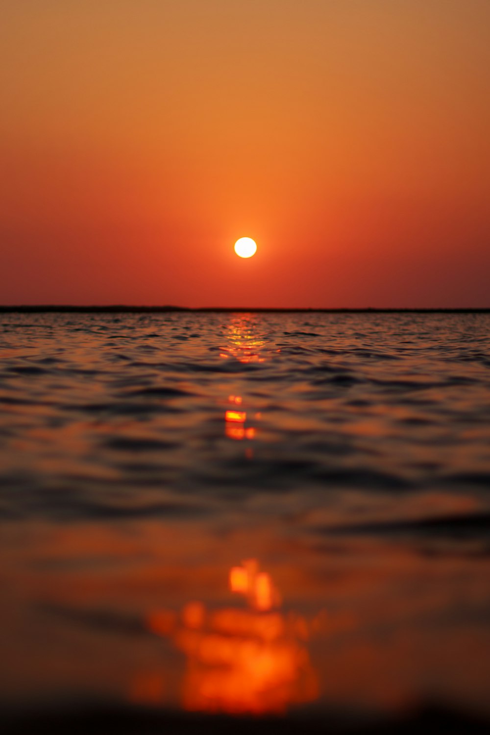 the sun is setting over the water in the ocean