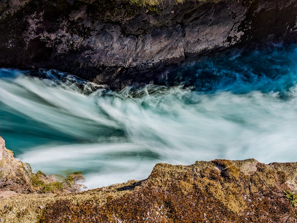 a large body of water near a rocky cliff