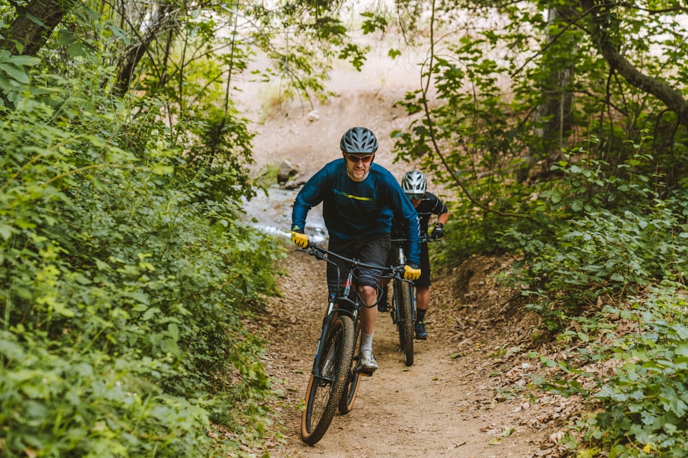 a man riding a bike down a dirt road