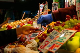 a person handing a person a piece of paper at a fruit stand