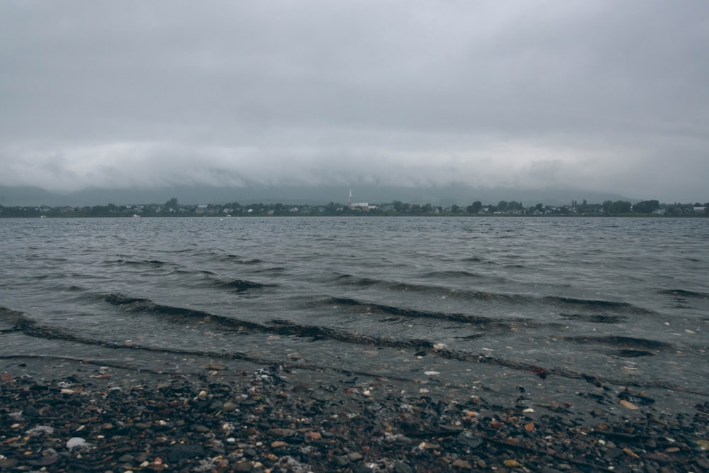 a body of water surrounded by rocks and pebbles