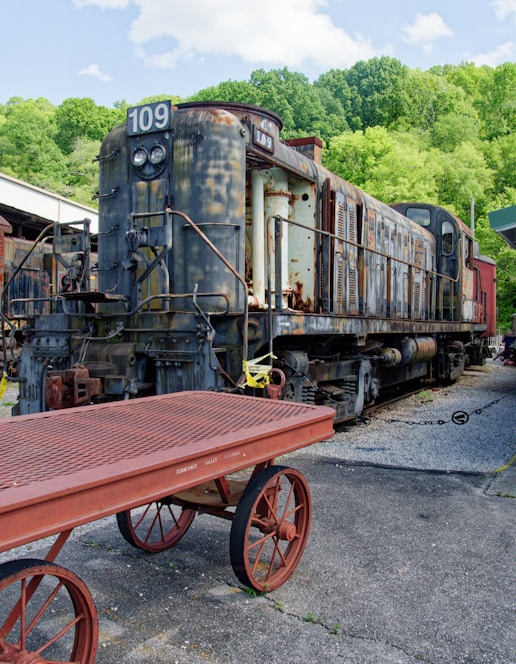 an old train sitting on the tracks next to a table