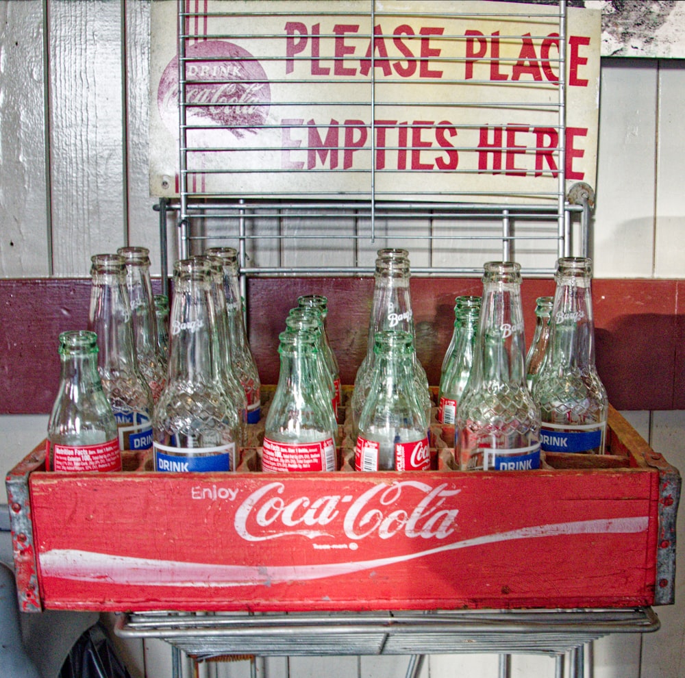 an old coca - cola machine with six bottles in it