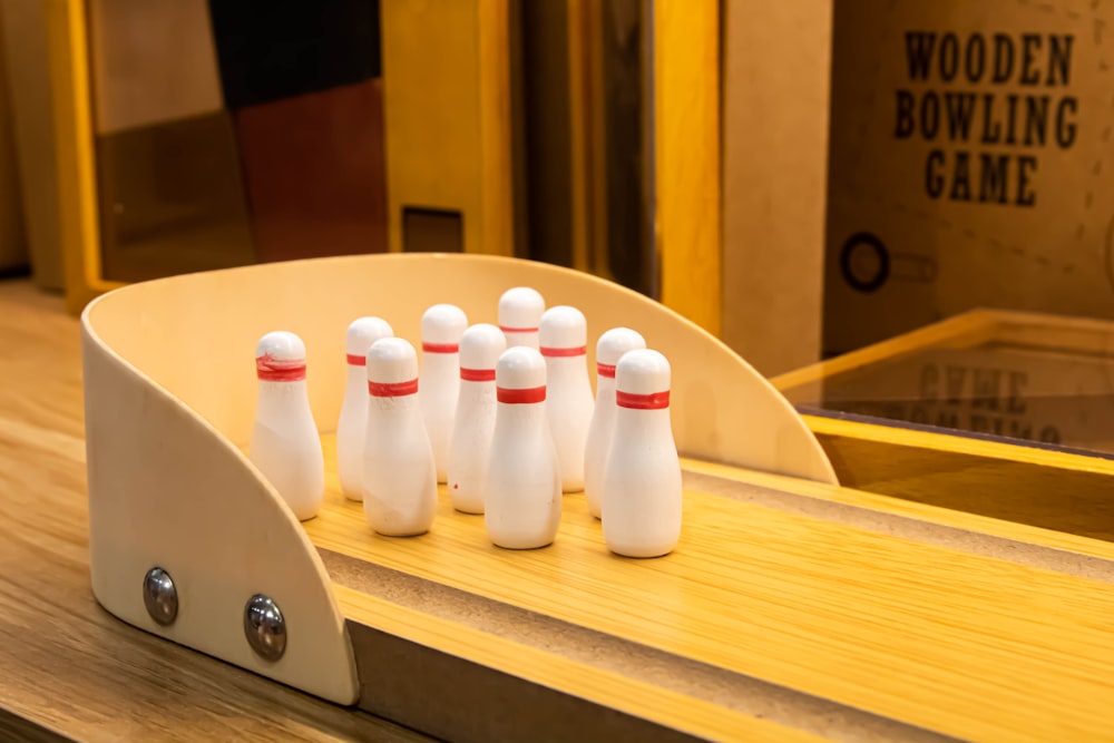 a group of white bowling pins sitting on top of a wooden table