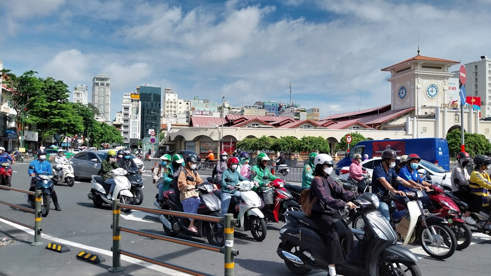 a group of people riding scooters down a street